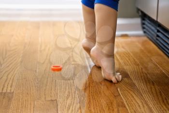 Royalty Free Photo of Feet of a Toddler Boy With Magnets in Front of a Refrigerator