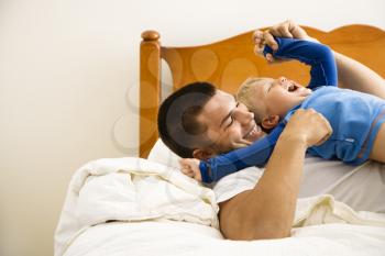Royalty Free Photo of a Father Tickling His Toddler Son