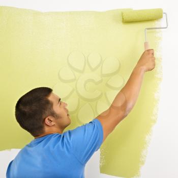 Royalty Free Photo of a Man Painting a Wall Using a Paint Roller
