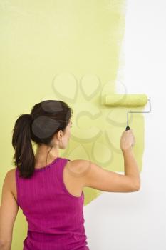 Royalty Free Photo of a Woman Painting a Wall With a Paint Roller