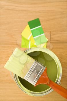 Royalty Free Photo of a Paintbrush Resting on a Paint Can With Color Samples