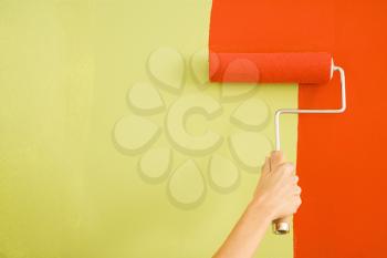 Royalty Free Photo of a Female Hand Painting Red over a Wall With a Paint Roller