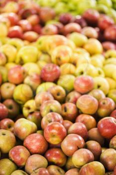 Royalty Free Photo of Red and Yellow Apples Piled on a Table at a Produce Market