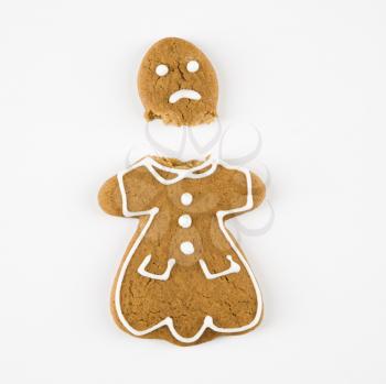 Frowning female gingerbread cookie broken in half.