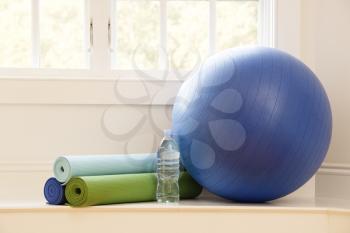 Royalty Free Photo of a Balance Ball, Exercise Mats and Bottled Water at a Gym by a Window