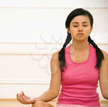 Royalty Free Photo of a Woman Sitting in a Lotus Position Practicing Yoga With Eyes Closed
