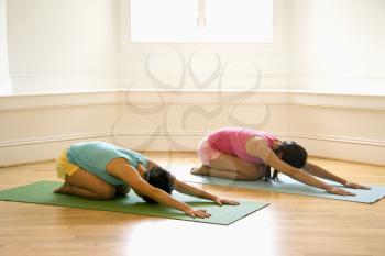 Royalty Free Photo of Two Young Women on Yoga Mats Doing Child's Pose
