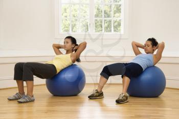 Royalty Free Photo of Two Woman Doing Ab Workouts on Balance Balls