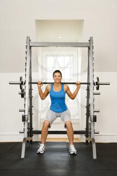 Royalty Free Photo of a Woman Lifting Weights in a Gym Smiling