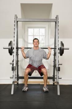 Royalty Free Photo of a Man at a Gym Lifting Weights on a Weight Machine