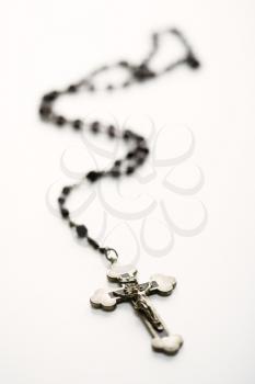 Christian rosary beads with crucifix on white background.