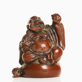 Happy laughing Buddha figurine with hand raised in blessing on white background.