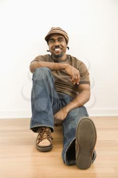 Royalty Free Photo of a Smiling Man Sitting on the Floor