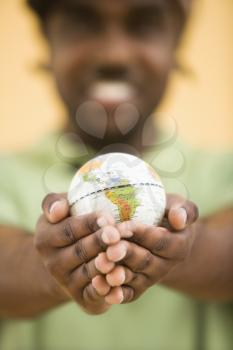 Royalty Free Photo of a Man Holding Out a Small Globe
