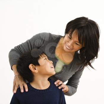 Asian mother smiling at young son.