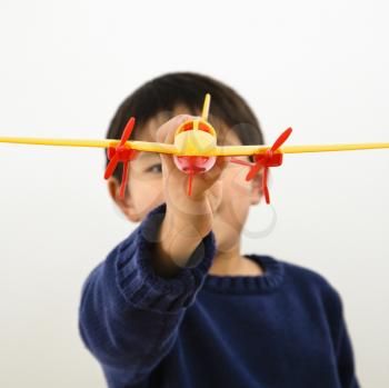 Royalty Free Photo of a Young Boy Playing With a Plastic Toy Airplane
