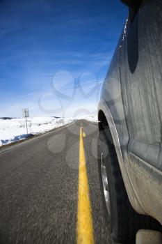 Royalty Free Photo of an SUV Driving Down the Road in Snowy Colorado During Winter