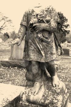 Royalty Free Photo of a Statue in a Graveyard of a Headless Cherub