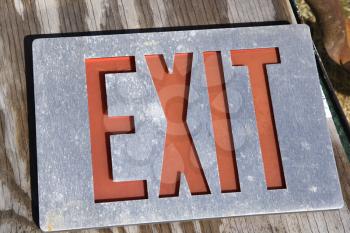 Royalty Free Photo of an Old Exit Sign Lying on Wood