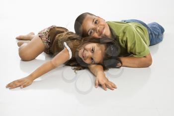 Royalty Free Photo of a Brother and Sister Lying on the Floor Smiling