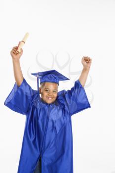 Royalty Free Photo of a Boy Wearing a Graduation Gown Holding a Diploma and Cheering