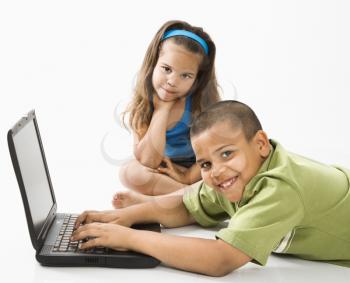 Royalty Free Photo of a Young Boy Using a Laptop While a Girl Watches