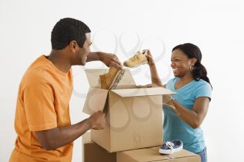 Royalty Free Photo of an African American Couple Packing Cardboard Boxes With Shoes