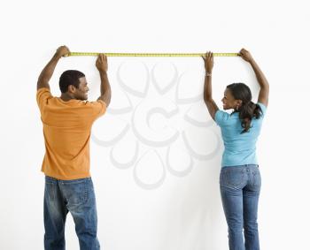 Royalty Free Photo of a Man and Woman Measuring a Wall