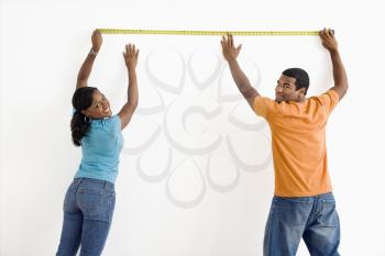 Royalty Free Photo of a Man and Woman Measuring a Wall