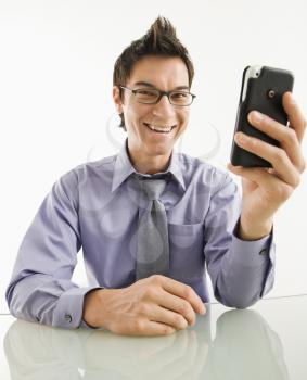 Royalty Free Photo of a Laughing Businessman Sitting Holding His PDA