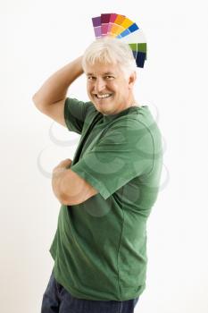 Royalty Free Photo of a Middle-aged Man Fanning Paint Swatches Over His Head