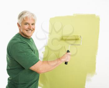 Royalty Free Photo of a Man Painting a Wall Green