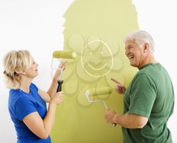 Royalty Free Photo of a Couple Painting a Wall Green