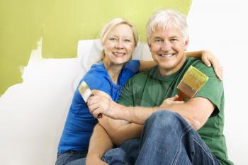 Royalty Free Photo of a Couple Sitting in Front of a Wall They are Painting Green