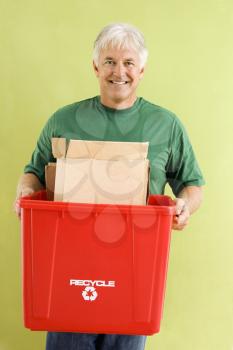 Royalty Free Photo of a Smiling Man Holding a Recycling Bin Full of Cardboard