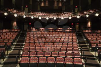 Rows of empty seats in theater seen from stage. Horizontal shot.