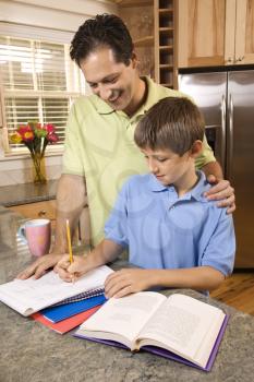 Man helping young boy with homework.  Vertically framed shot.