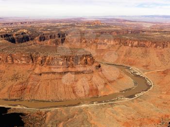 Aerial view of an arid, craggy landscape with a river running through it. Horizontal shot.