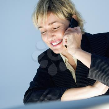 Caucasian businesswoman smiling talking on cellphone.