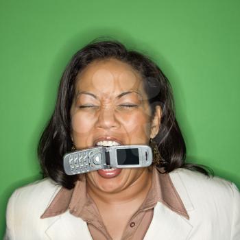 Portrait of African American businesswoman biting cellphone.