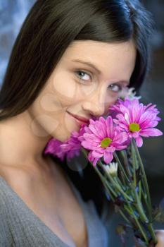 Portrait of pretty young Caucasian woman holding bouquet of flowers.