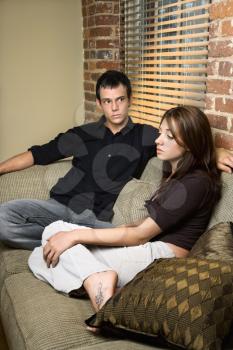 Young couple at home sitting on living room sofa