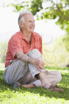 Royalty Free Photo of a Man Sitting on the Lawn