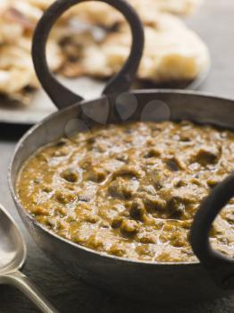Royalty Free Photo of a Kali Dahl Served in a Karahi With Naan Bread