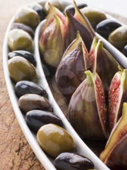 Royalty Free Photo of a Dish of Green and Black Olives with Fresh Figs