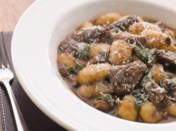 Royalty Free Photo of Oxtail Braised in Red Wine With Basil Gnocchi and Parmesan Cheese