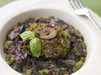 Royalty Free Photo of Herb Crusted Portabello Mushroom with Red Wine Risotto and Pesto Dressing