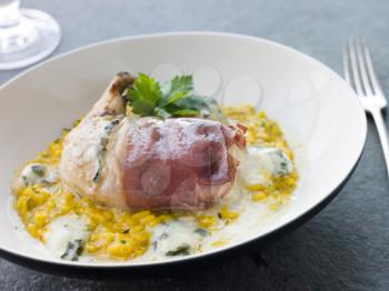 Royalty Free Photo of a Chicken Breast Wrapped in Parma Ham with Gorgonzola Cheese and Risotto