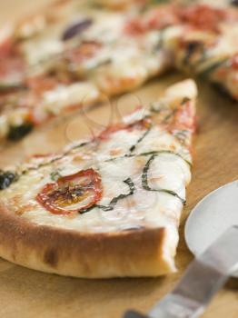 Royalty Free Photo of a Slice of Tomato Mozzarella Aubergine and Basil Pizza