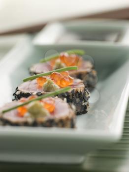 Royalty Free Photo of Seared Yellow Fin Tuna Rolled in Sesame Seeds With Wasabi and Salmon Roe